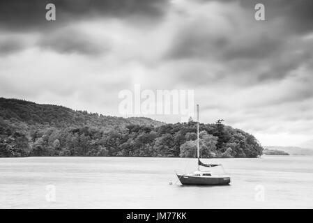 Una barca a vela in una rilassante lago in tempesta si sta avvicinando. Regno Unito Foto Stock