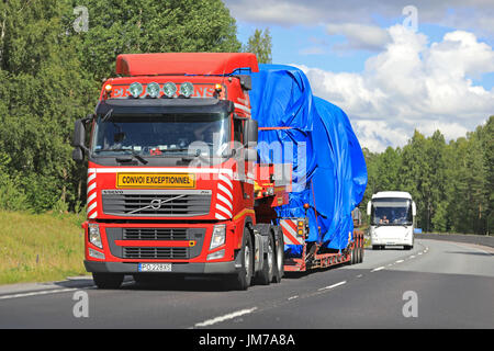 VIHTI, Finlandia - 21 luglio 2017: Rosso Volvo FH semi rimorchio di Erontrans traina un carico di larghezza trasporto coperto con telone lungo l'autostrada in estate. Foto Stock