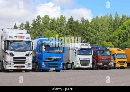 SALO, Finlandia - 22 luglio 2017: Scania R500, Volvo FH, DAF XF, Sisu e Iveco carrelli di trasporto parcheggiato presso il cantiere di asfalto di un arresto carrello su una chiara da Foto Stock