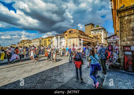Il medievale Ponte Vecchio a Firenze Italia con la folla di turisti shopping come una tempesta si avvicina al pomeriggio Foto Stock
