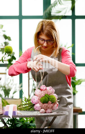 Fioraio rende bouquet di fiori Foto Stock