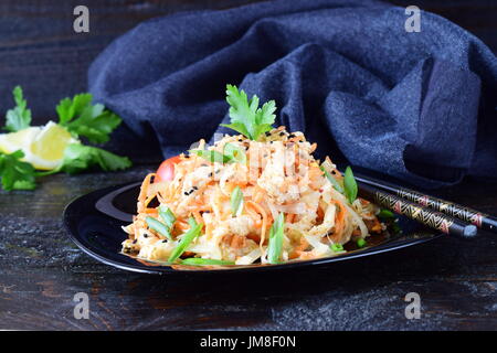 Il coreano la cucina tradizionale. Materie di pollo marinato in salsa di soia, spezie, le cipolle e le carote su una piastra nera su sfondo scuro. Cibo sano. Mangiare sano concetto. Foto Stock