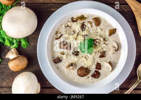 Una foto aerea di una piastra di un fungo minestra in crema con champignon, cremini e prezzemolo fresco, con formaggio grattugiato Foto Stock