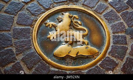 Lion metallo stucco di artigianato e rotondo modello di ciclo di visualizzazione sul marciapiede della città vecchia di Heidelberg, Germania Foto Stock