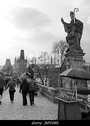 Ponte Carlo (Karlův Most) e la statua di Sant'Agostino, con Malá Strana e le Torri del Ponte oltre, Praga, Repubblica Ceca: Bianco e nero Foto Stock