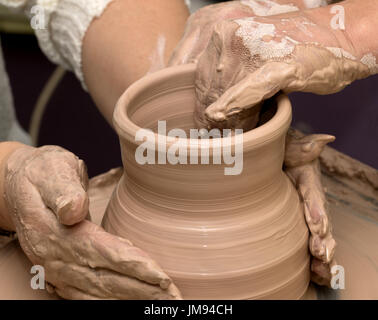 Due donne nel processo di realizzazione di vaso di creta sulla ruota di ceramiche. Vasai al lavoro. Foto Stock