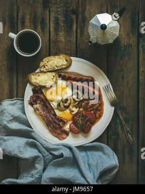 Prima colazione inglese tradizionale con uova fritte, salsicce, funghi e pancetta Foto Stock