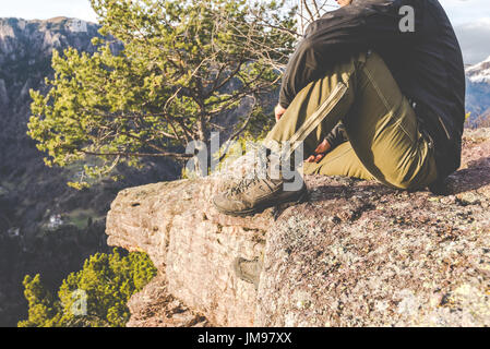 Escursionista in piedi sulle rocce e contempla un bellissimo paesaggio di montagna - wanderlust concetto di viaggio con gli sportivi a escursione nella natura selvaggia Foto Stock