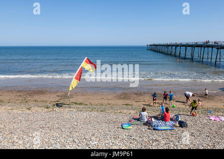 Un giallo e rosso di sicurezza bandiera di avvertimento sulla spiaggia di Saltburn dal mare,Inghilterra,UK Foto Stock