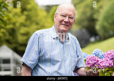 Ritratto di uomo anziano godendo giardino di casa Foto Stock