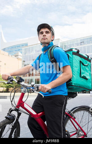 Servizi di corriere in bicicletta a consegnare il cibo in città Foto Stock