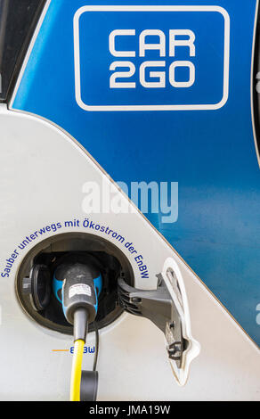 Elettrico auto condivisa veicolo di car2go flotta essendo caricato in corrispondenza di una stazione di carica azionato dal fornitore di energia EnBW, Stoccarda, BADEN-WUERTTEMBERG, germa Foto Stock