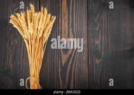 Punte di ripe golden grano su un sfondo di legno. Il concetto di agricoltura e di raccolta. Foto Stock