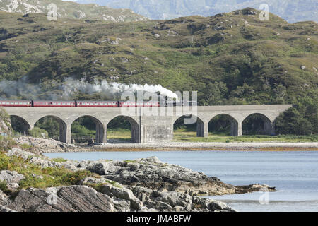 Giacobita treno a vapore attraversando Loch nan umbh viadotto, Scotland, Regno Unito. Foto Stock
