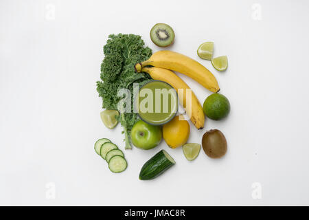 Vista dall'alto in basso di uno stile di vita sano frullato verde con frutta e verdura su uno sfondo bianco. Il concetto di stile di vita. Foto Stock