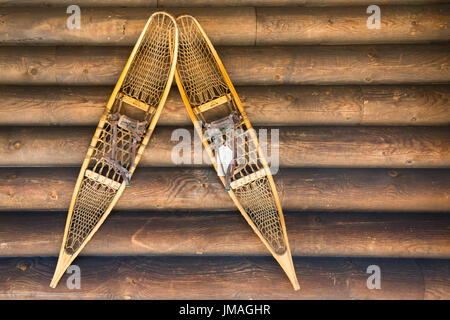 Legno di antiquariato scarpe da neve montate sul Log la parete della cabina Foto Stock