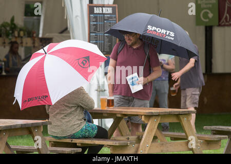 Cambridge, Regno Unito. 27 Luglio, 2017.Gli appassionati di musica arriva sotto la pioggia alla partenza per il 53 Festival del Folk di Cambridge in Cherry Hinton Hall il giovedì pomeriggio. Credito: Geoffrey Robinson/Alamy Live News Foto Stock