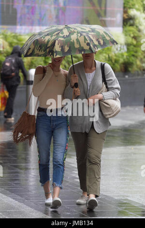 Londra, Regno Unito. 27 Luglio, 2017. I pedoni a ovest di Londra vengono catturati con scrosci di pioggia in un giorno di condizioni atmosferiche variabili nella capitale Credito: amer ghazzal/Alamy Live News Foto Stock