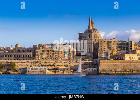 La Valletta, Malta - Saint Paul Cathedral e le antiche mura della Valletta con barche a vela di mattina Foto Stock