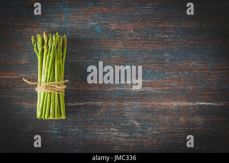 Mazzetto di freschi Asparagi verdi legato grezzo corda sottile. Vista superiore Foto Stock