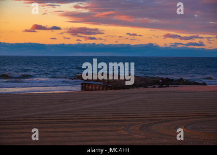 Il cielo sopra l'oceano è una combinazione di colorati di blu, arancione e il magenta poco dopo l'alba. Foto Stock