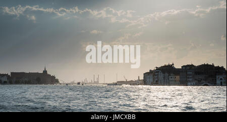Cieli drammatici sul Canale della Giudecca mentre il sole tramonta su Venezia. Foto Stock