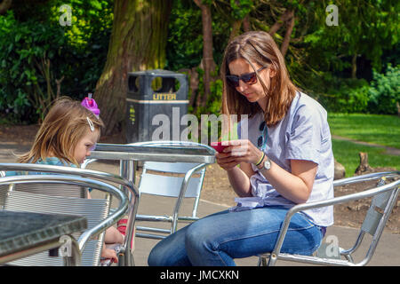 Donna in jeans lookinga al telefono, Sheffield South Yorkshire Foto Stock