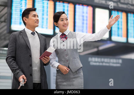 Cinese sorridenti hostess della compagnia aerea e il passeggero Foto Stock