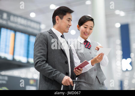 Cinese sorridenti hostess della compagnia aerea e il passeggero Foto Stock