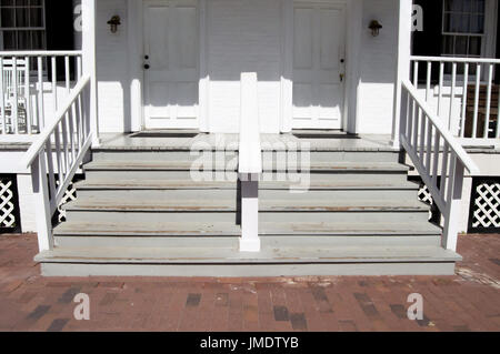 Un vecchio portico bianco e passaggi con due porte. Foto Stock