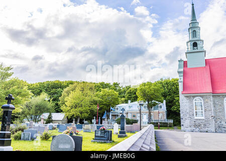 Ile D'Orleans, Canada - 1 Giugno 2017: Saint-Jean chiesa del cimitero con lapidi di pietra e cielo blu in estate Foto Stock