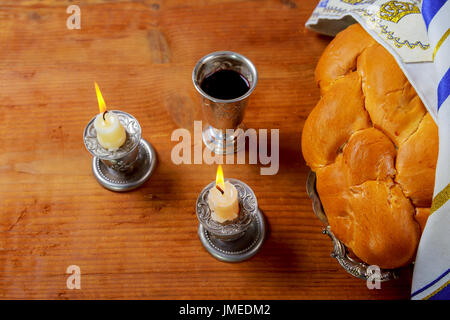 Immagine di sabato - kiddush Silver Cup, candelieri in cristallo con candele accese e challah challahs Foto Stock