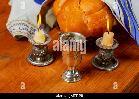 Immagine di sabato - kiddush Silver Cup, candelieri in cristallo con candele accese e challah challahs Foto Stock