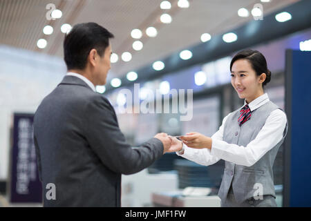 Cinese sorridenti hostess della compagnia aerea e il passeggero Foto Stock