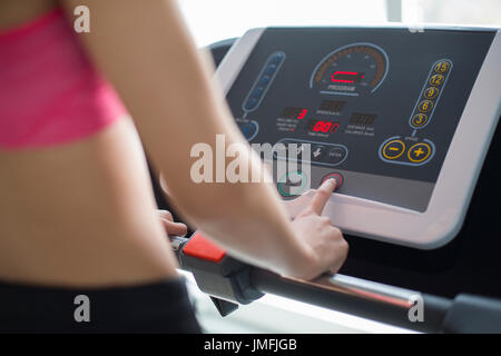 Giovane donna cinese esercita sul tapis roulant in palestra Foto Stock