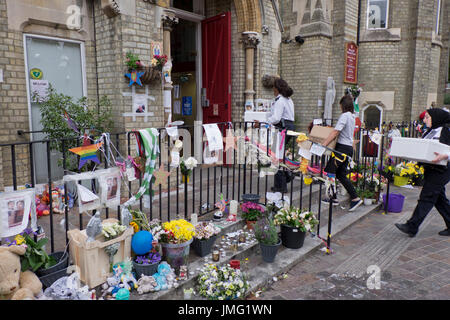 Gli ufficiali di polizia prendendo il cibo ad un incontro pubblico di residenti locali a Notting Hill Chiesa Metodista vicino al sito del disastro incendio al Grenfell Torre di Londra,l'Inghilterra,UK Foto Stock