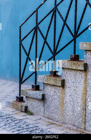 Al di fuori di vintage strair con ringhiera metallica su sfondo blu. Strada pavimentata con piastrelle Foto Stock