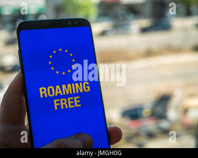 Free Roaming in Euro, dell'UE. Il cellulare in mano con sfondo di viaggio. Concetto Foto Stock