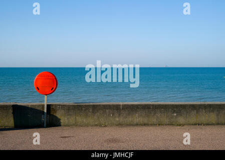 Rosso brillante salvagente contro il mare blu, Brighton, Regno Unito Foto Stock