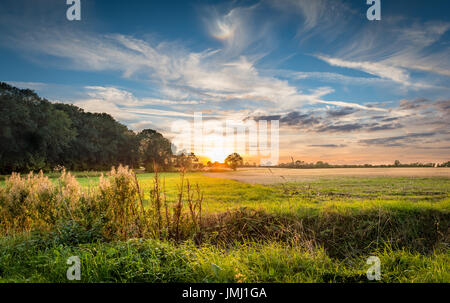 Un caldo tramonto segue alla fine di un tipico di una giornata estiva nel Lincolnshire campagna, vicino al piccolo villaggio di Aslackby, Lincolnshire, Regno Unito Foto Stock