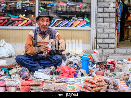 Leh, Ladakh, India, luglio 14, 2016: locale l uomo è la vendita di spezie su un marciapiede mercato di Leh, Ladakh distretto dello stato del Kashmir, India Foto Stock