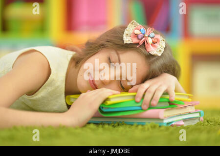 Poco carino ragazza di addormentarsi sui libri Foto Stock