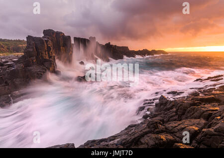Fiery sunrise seascape al Bombo cava sulla costa sud del NSW, Australia Foto Stock