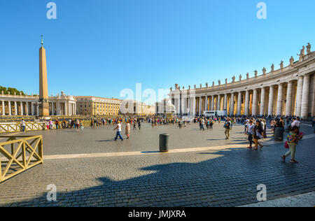 St Peters Square nella Città del Vaticano in una calda giornata estiva con i turisti. Questa è la meno shot visualizza distanza dalla cattedrale Foto Stock