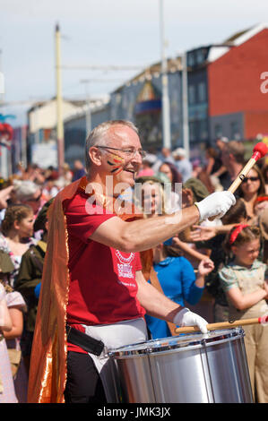 Felice,sorridente batterista Samba prendendo parte al Blackpool Carnevale Internazionale Foto Stock
