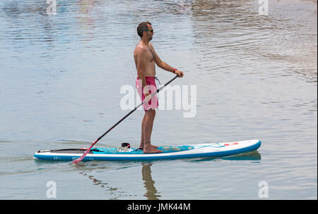 Stand Up Paddle paddleboarder boarder a Lyme Regis, Dorset in luglio Foto Stock