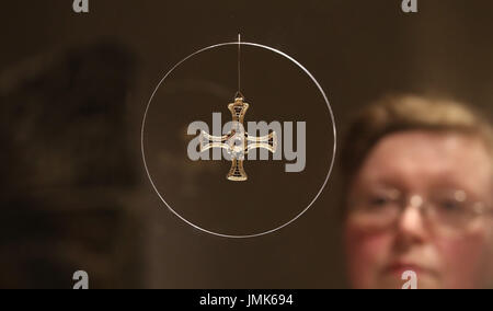 Mostra officer Marie-Therese Mayne guarda al St Cuthbert's oro e granato croce pettorale presso la Cattedrale di Durham, uno di una serie di notevoli artefatti anglosassone che sono andati in mostra presso la cattedrale. Foto Stock