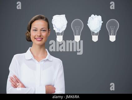 Digital composito della donna in piedi accanto a lampadine con carta sgualcita sfere nella parte anteriore di Blackboard Foto Stock