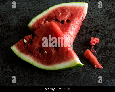 Fette di cocomero su un nero ardesia Foto Stock