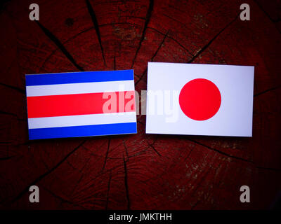 Costa Rican bandiera con bandiera giapponese su un ceppo di albero isolato Foto Stock
